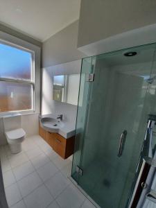 a bathroom with a shower and a toilet and a sink at Tauranga - Big, beautiful Villa on the water! in Tauranga