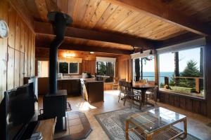 The Cedar House في Otter Rock: مطبخ وغرفة معيشة مع موقد في المنزل