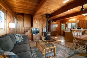Cabaña con sala de estar con sofá y TV. en The Cedar House en Otter Rock