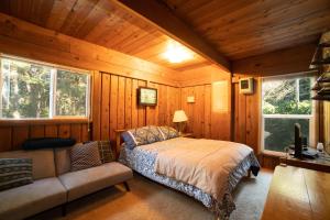 um quarto com uma cama e um sofá numa cabina em The Cedar House em Otter Rock