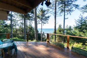 een houten terras met uitzicht op de oceaan bij The Cedar House in Otter Rock