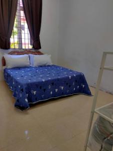 Kampong Permatang SerentangにあるHomestay Anjung Meranti Kids Poolの青いシーツが付いたドミトリールームのベッド1台分です。
