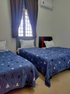 Kampong Permatang SerentangにあるHomestay Anjung Meranti Kids Poolの青いシーツと窓が備わる客室で、ベッド2台が備わります。