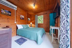 a bedroom with a bed in a wooden cabin at Casa Di Fiori in Apiúna