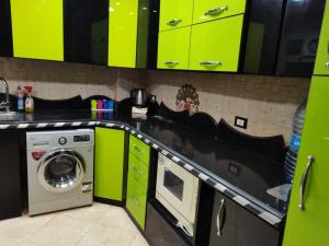 a kitchen with lime green cabinets and a washing machine at Alnahas St. Two-Bedroom Apartment With Jacuzzi in Tanta