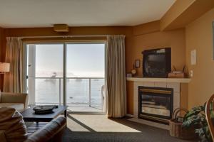 a living room with a fireplace and a large window at Waters Edge 312 in Lincoln City
