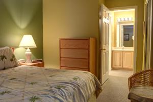 a bedroom with a bed and a lamp and a door at Waters Edge 312 in Lincoln City