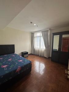 a bedroom with a bed and a large window at apartemen in Jakarta