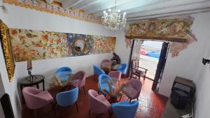 Habitación con sillas azules y rosas y lámpara de araña. en La Llave 351, en Cusco
