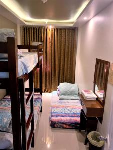 a room with two bunk beds and a desk at The Ideal Place in Cauayan city in Cauayan City