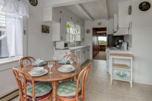 a kitchen with a wooden table and chairs and a dining room at The Hamptons in Rockaway Beach