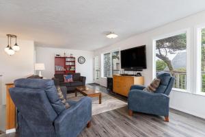 Una sala de estar con dos sillas y un televisor de pantalla plana. en The Lakeside Caboose, en Rockaway Beach