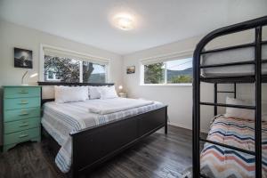 a bedroom with a bunk bed and two windows at The Lakeside Caboose in Rockaway Beach