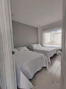 3 łóżka w pokoju z oknem w obiekcie Cabañas Compostela Gigante w mieście Gigante
