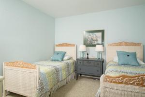 a bedroom with two beds and a table with a night stand at Waters Edge 214 in Lincoln City