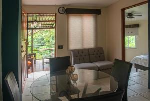 ein Wohnzimmer mit einem Glastisch und einem Sofa in der Unterkunft Organic Garden in San José