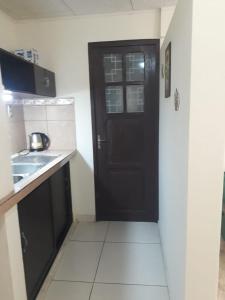 a kitchen with a black door and a sink at Nia in Tarija
