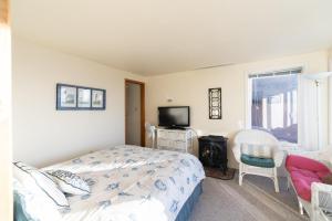 a bedroom with a bed and a flat screen tv at Whale Pointe in Depoe Bay