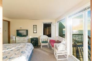 a bedroom with a bed and a tv and a balcony at Whale Pointe in Depoe Bay +16 photos