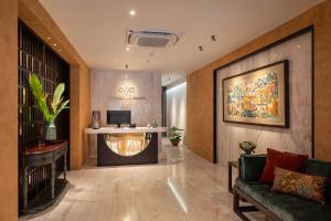 ハノイにあるLe Parfum Apartment and Hotelのソファとデスクのあるホテルのロビー
