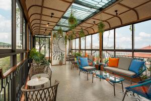 d'un balcon avec des chaises, des tables et des fenêtres. dans l'établissement Le Parfum Apartment and Hotel, à Hanoï