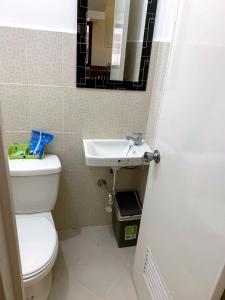 a bathroom with a white toilet and a sink at The Ideal Place in Cauayan city in Cauayan City