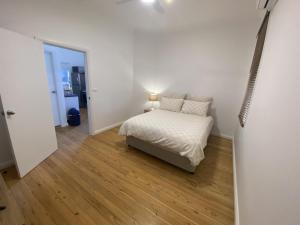 1 dormitorio con 1 cama en una habitación blanca en Perrington Estate, en Nyngan