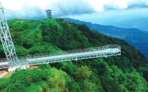 a suspension bridge in the middle of a mountain at Green and Green in Vagamon
