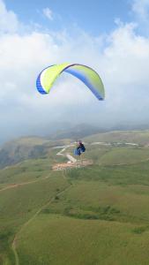 a person flying a parachute in the sky at Green and Green in Vagamon