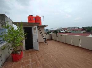 Pulauberayan的住宿－Private guest house，一座建筑的顶部,阳台有两个红色的储油罐