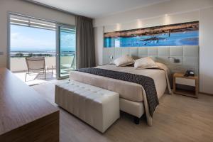 a bedroom with a bed and a view of the ocean at Laguna Park Hotel 4Superior in Bibione