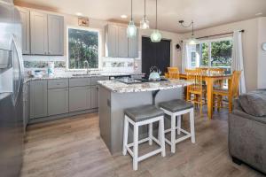 a kitchen with white cabinets and a kitchen island with bar stools at Beverly Beach Overlook in Newport