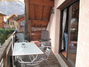 une table blanche et des chaises sur un balcon dans l'établissement Charmant 4 pièces pour 6 pers., à 300m des pistes avec Wi-Fi, balcon et parking, Villeneuve - FR-1-762-3, à La Salle Les Alpes