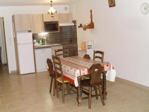 eine Küche mit Tisch und Stühlen und einem Kühlschrank in der Unterkunft Appartement 3 pièces, Wi-Fi, Parking, proche des pistes - Briançon - FR-1-762-36 in Briançon