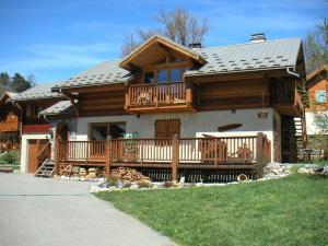 a large wooden house with a porch and a deck at Charmant 2 Pièces + Coin Montagne - Parking Privé, WiFi, Proche Pistes - FR-1-762-31 in Saint-Chaffrey