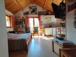 a bedroom with a bed and a kitchen in a room at Charmant 2 Pièces + Coin Montagne - Parking Privé, WiFi, Proche Pistes - FR-1-762-31 in Saint-Chaffrey