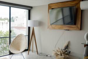 a living room with a mirror and a chair and a window at NUEVO depto - Glorieta Chapalita in Guadalajara