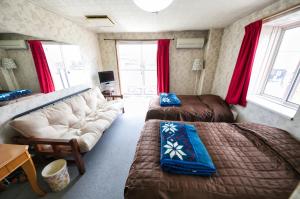salon z 2 łóżkami i kanapą w obiekcie Hotel Camelot w mieście Fujikawaguchiko