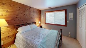 una camera da letto con un letto e una parete con accenti in legno di Commodore 1 a Depoe Bay