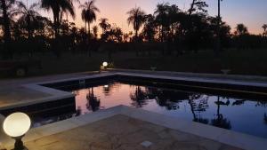 a pool with a lamp and a sunset in the background at Residencia de Coco, Künstlerhaus in Piribebuy, in Piribebuy