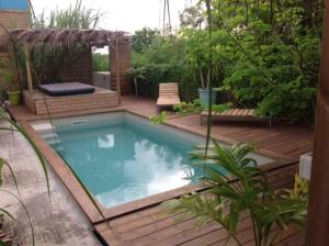 大博格LE ZAYENN gîte côté canne的花园内的游泳池,花园内设有木甲板和家具