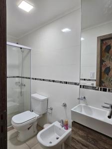 a white bathroom with a toilet and a sink at Rio Parana alta Vista in Corrientes +19 photos