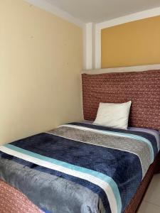 a small bedroom with a bed with a pillow at CASA LARA - Departamento equipado, 2 dormitorios in Lima