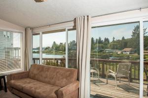 un soggiorno con divano e una grande finestra di Lake Point Hideaway a Neotsu