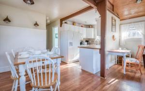 リンカーンシティにあるTaft Cottageの白いキャビネット、テーブルと椅子付きのキッチンが備わります。