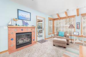 a living room with a fireplace and a chair at The Break in Pacific City