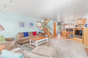 a living room with a couch and a staircase at The Break in Pacific City