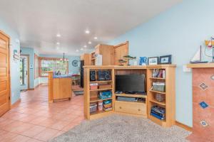a living room with a flat screen tv in a wooden entertainment center at The Break in Pacific City