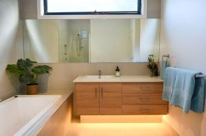 Un baño con bañera, lavabo y espejo. en Flinders Haven, en Flinders 18 fotos más