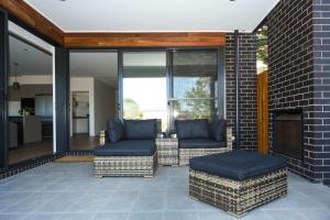 un patio con 2 sillas y una chimenea en Flinders Haven, en Flinders